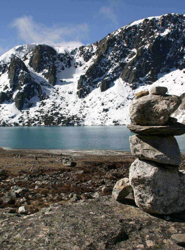 a pile of rocks in front of a lake