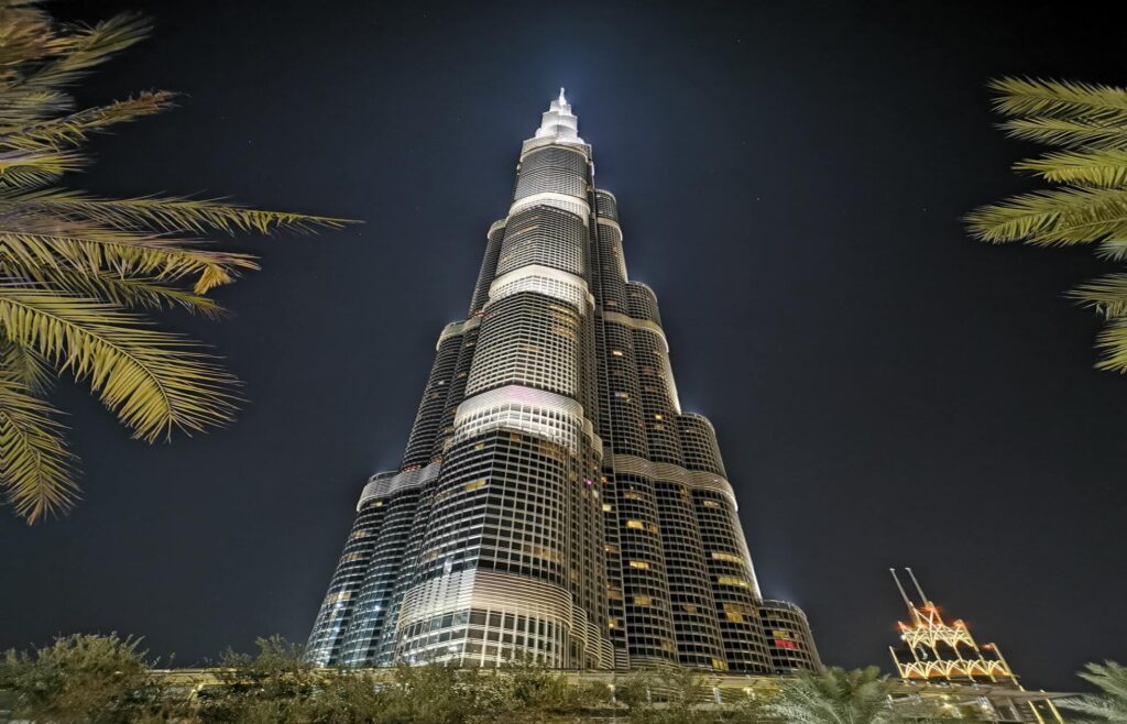 a tall burj khalifa building with lights at night