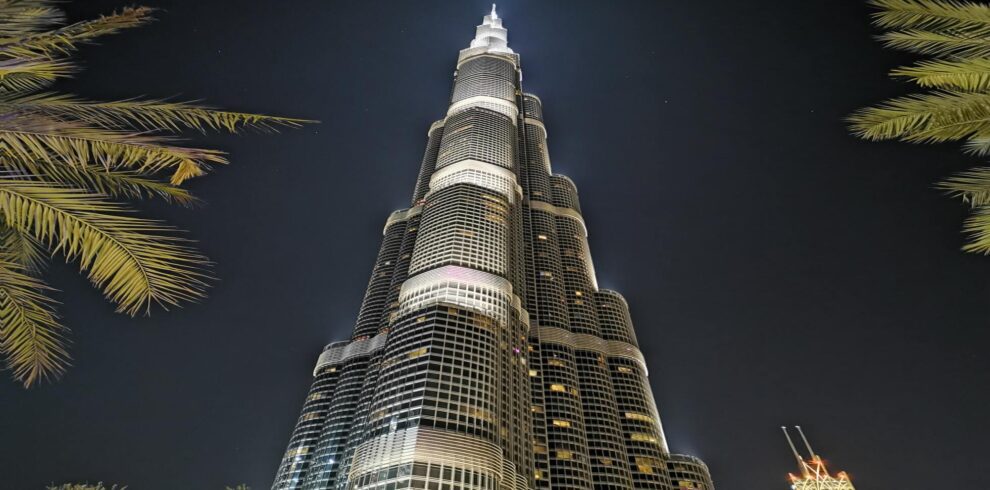 a tall burj khalifa building with lights at night