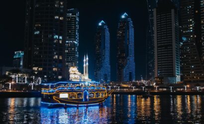 a boat in the water with lights which we can say "Dhow Cruise"