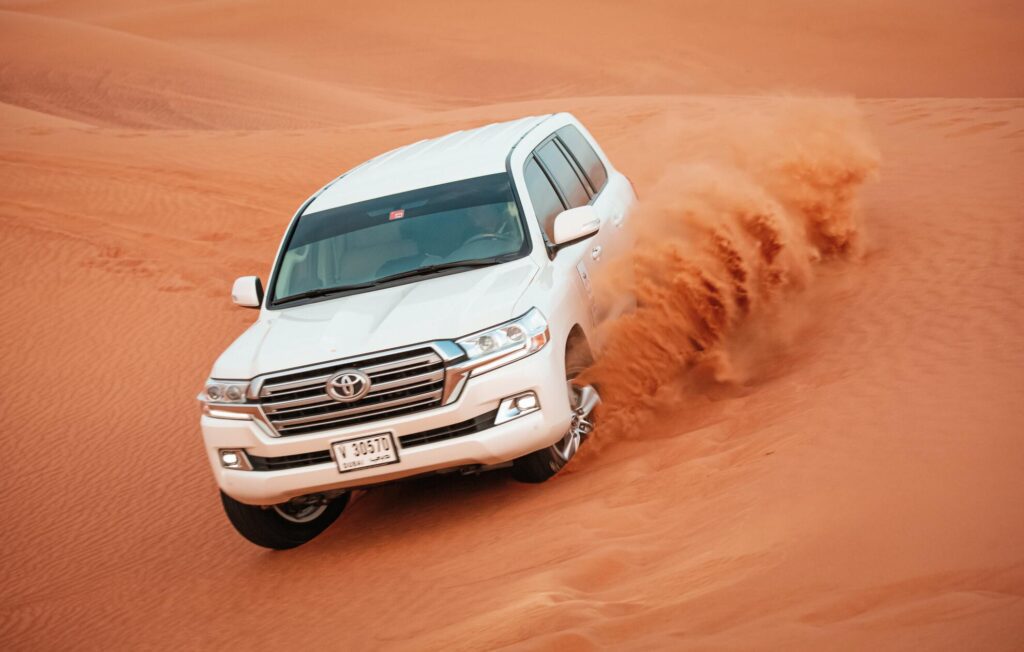 a car driving through a sand dune in Dubai desert