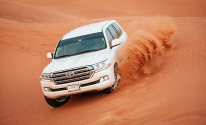 a car driving through a sand dune in Dubai desert