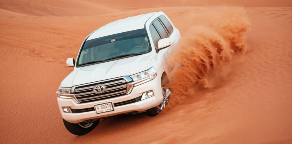 a car driving through a sand dune in Dubai desert