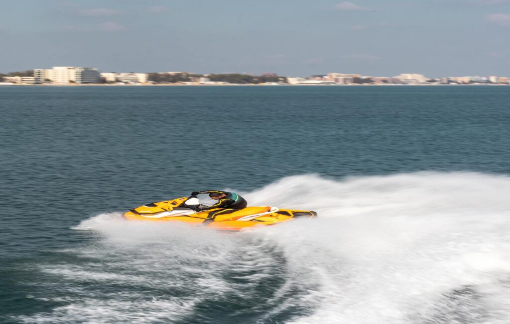 a guy riding yellow jet ski in the sea